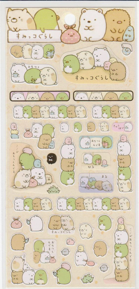 A sheet of Sumikko Gurashi stickers featuring various characters with gold foil accents on a beige background.